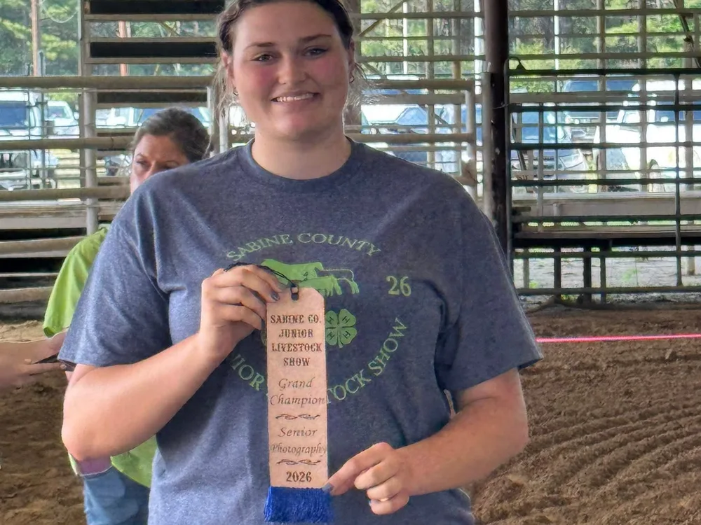 A Sabine County youth holding a Grand Champion ribbon at the Show